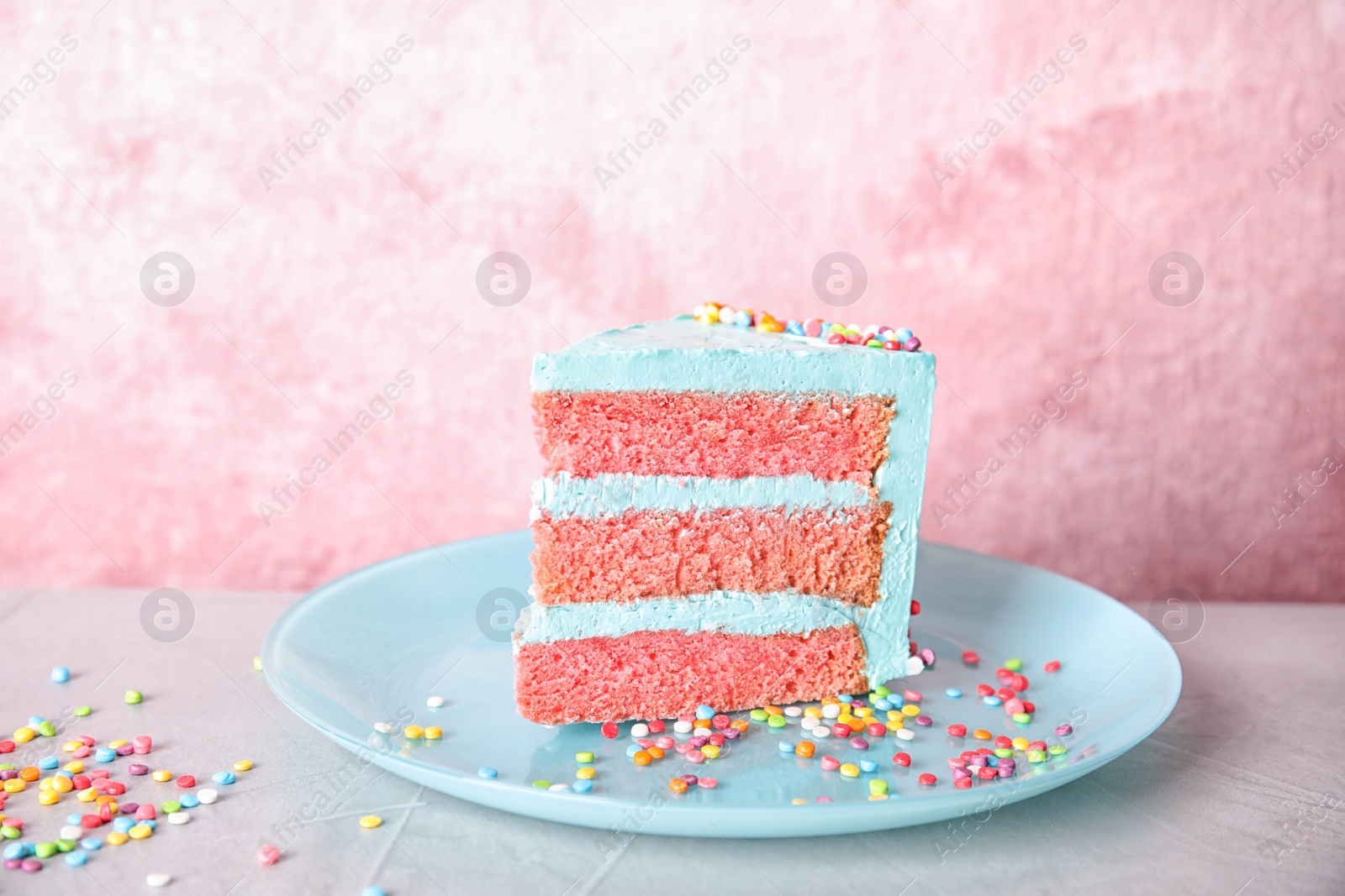 Photo of Slice of fresh delicious birthday cake on table against color background