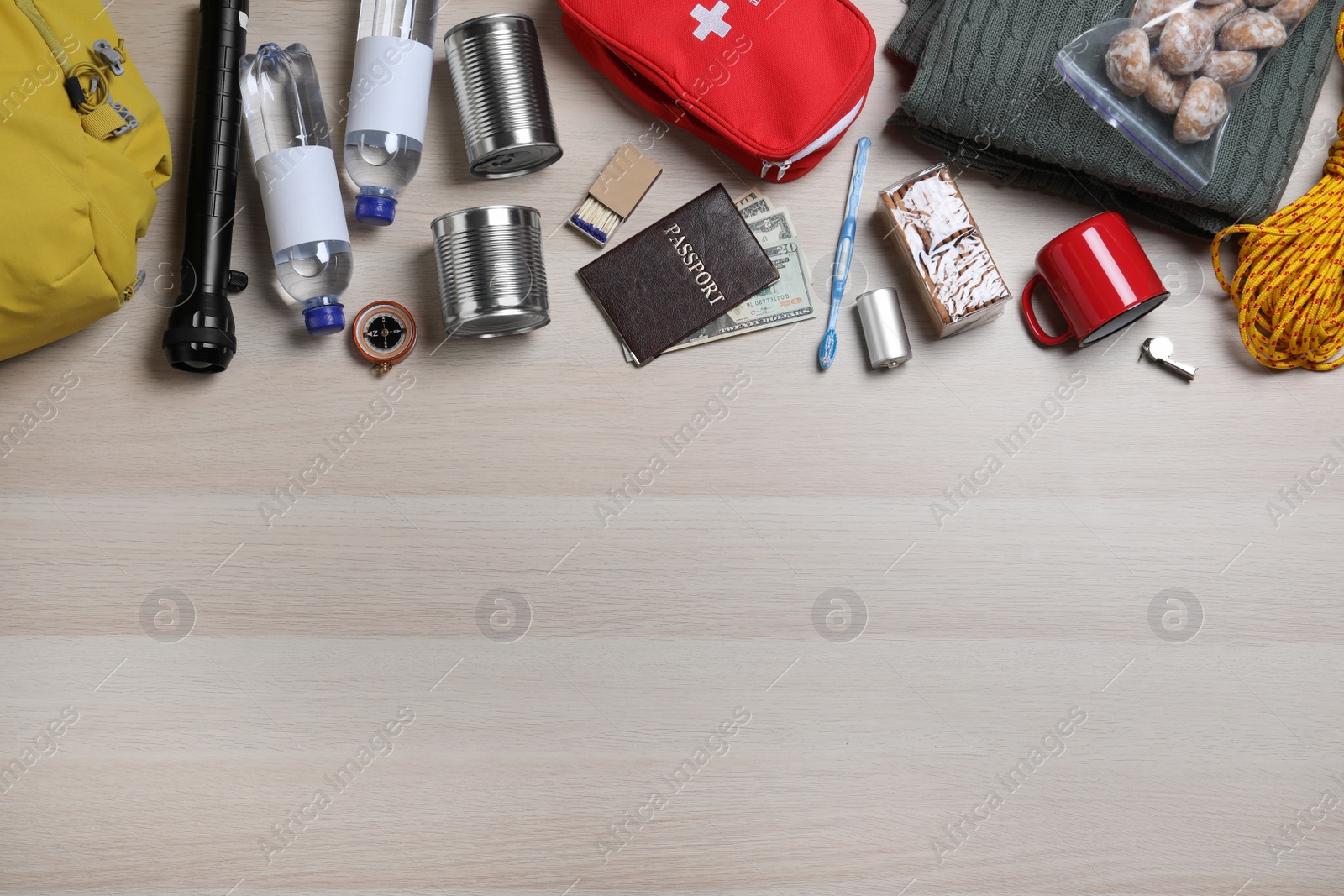 Photo of Earthquake supply kit on wooden table, flat lay. Space for text