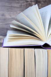 Photo of Different books against wooden background, closeup view