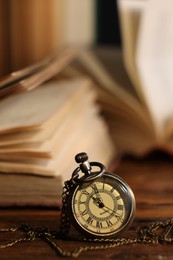 Photo of Pocket clock with chain on table, closeup