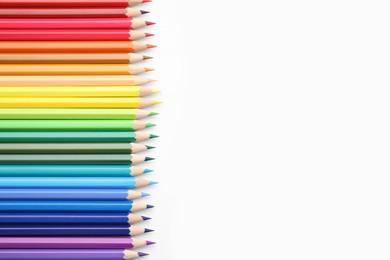 Many colorful wooden pencils on white background, flat lay. Space for text