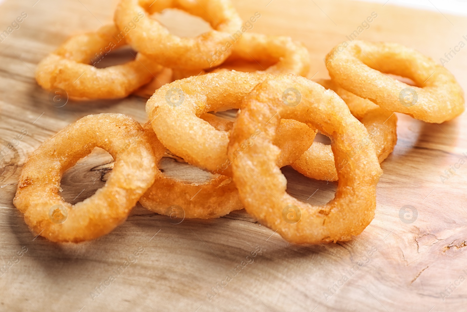 Photo of Fried onion rings on wooden background, closeup