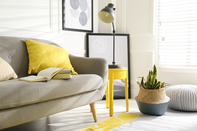 Photo of Stylish living room with sofa. Interior design in grey and yellow colors