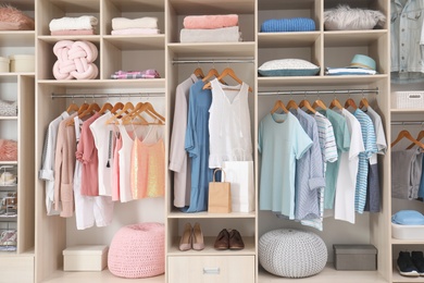 Photo of Stylish clothes, shoes and accessories in large wardrobe closet