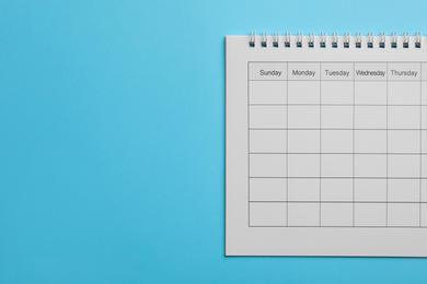 Photo of Blank calendar on light blue background, top view. Space for text