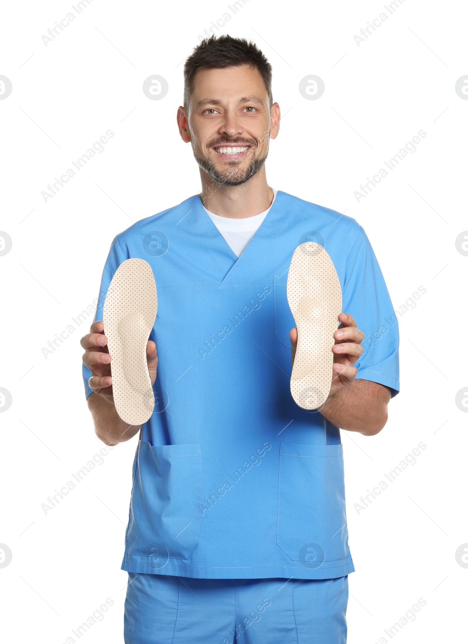 Photo of Handsome male orthopedist showing insoles on white background