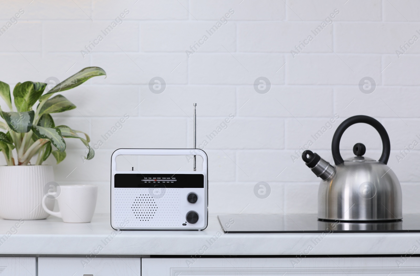 Photo of Stylish radio on kitchen counter near white brick wall