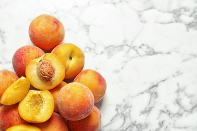 Photo of Pile of delicious ripe peaches on marble background, top view