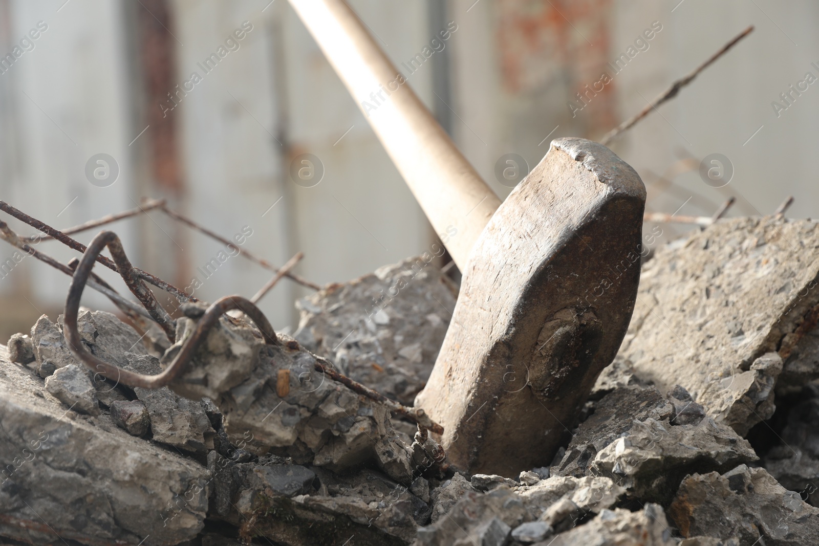 Photo of Sledgehammer on pile of broken stones outdoors, closeup