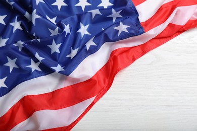 American flag on white wooden table, top view. Space for text