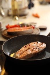 Photo of Frying pan with fresh tasty salmon steak on stove