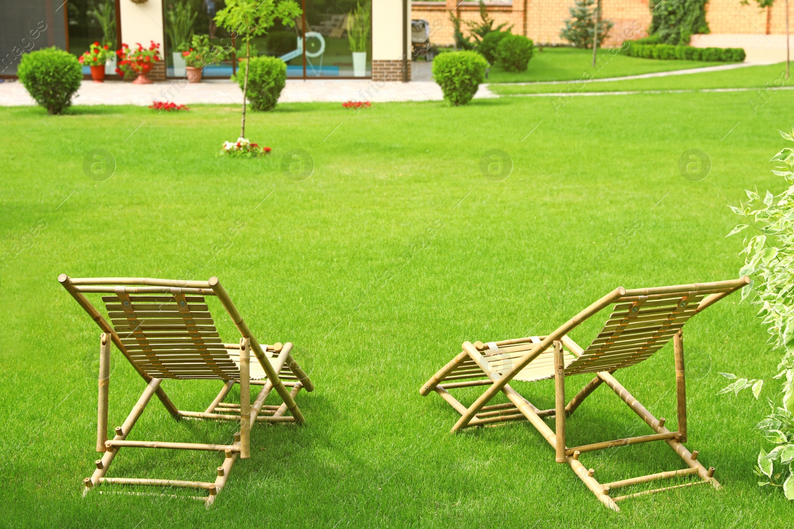 Photo of Wooden deck chairs in beautiful garden on sunny day