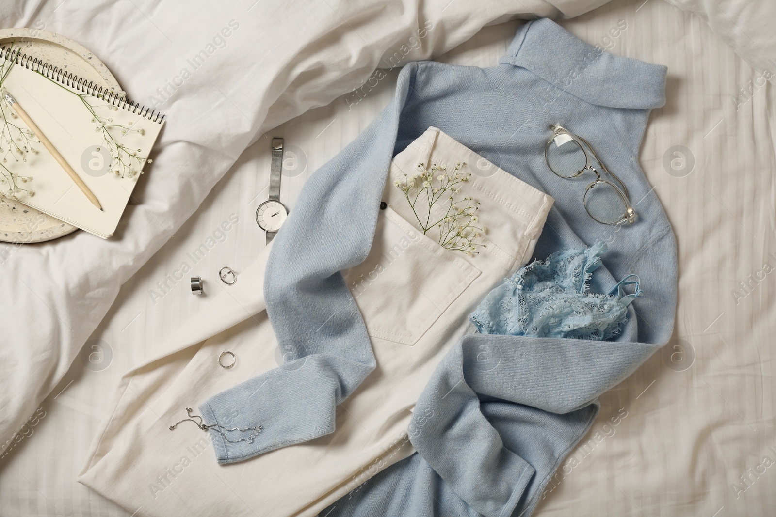 Photo of Stylish look with cashmere sweater, flat lay. Women's clothes and accessories on bed