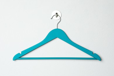 Photo of Empty turquoise clothes hanger on white wall