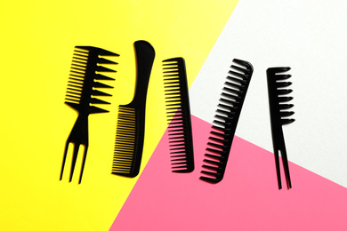 Photo of Set of black combs on color background, flat lay