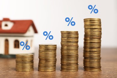 Image of Mortgage rate. Stacked coins, percent signs and model of house