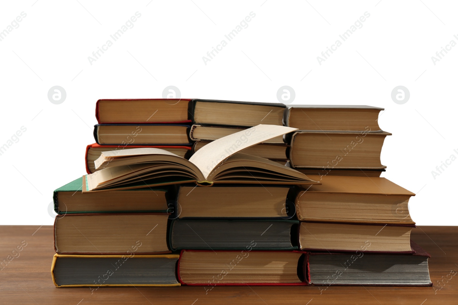 Photo of Many books on wooden table against white background. Library material