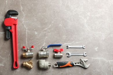 Flat lay composition with plumber's tools and space for text on grey background