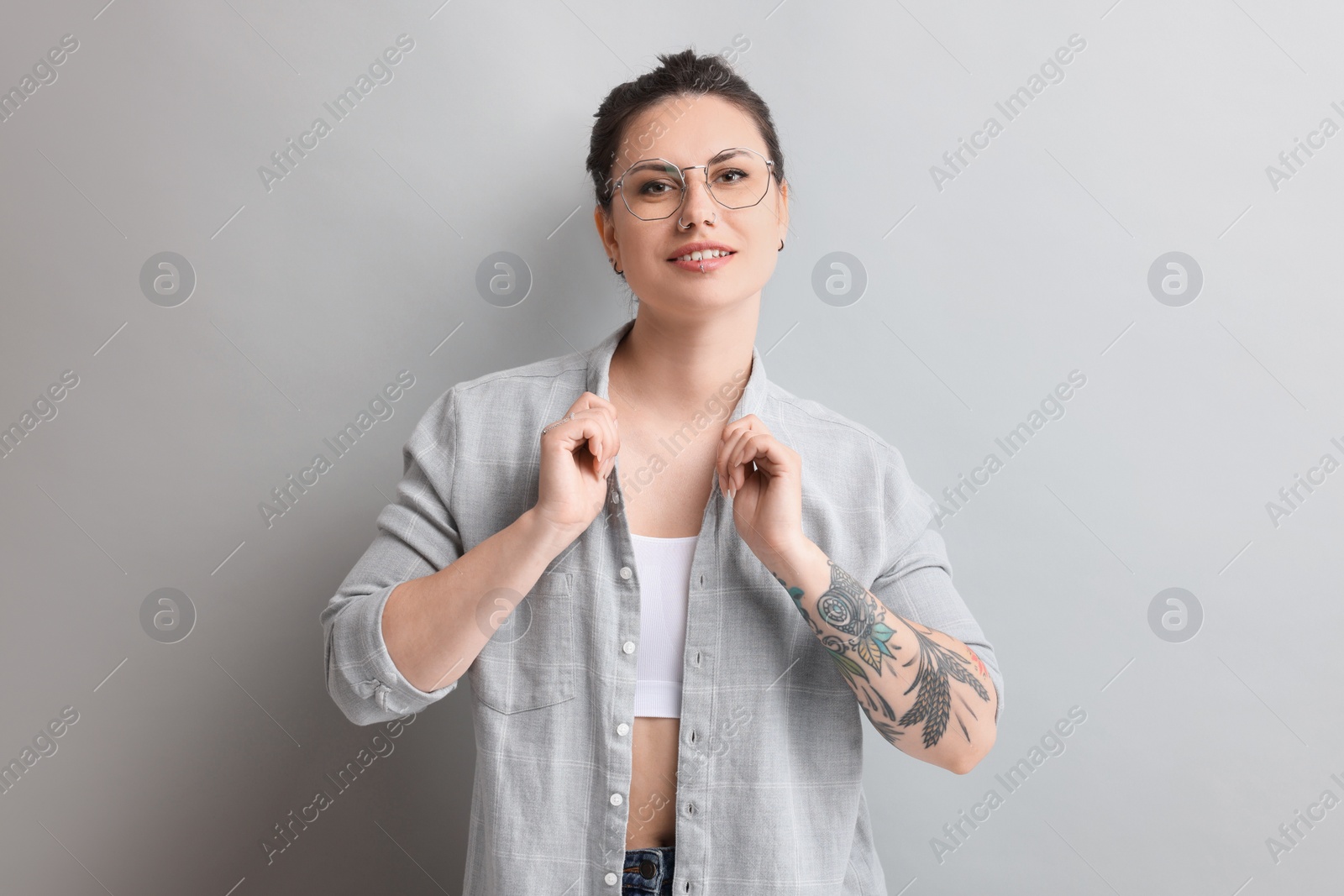 Photo of Portrait of beautiful tattooed woman on gray background