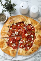 Photo of Flat lay composition of tasty galette with tomato, thyme and cheese (Caprese galette) on white marble table