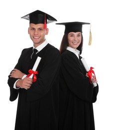 Photo of Happy students in academic dresses with diplomas on white background