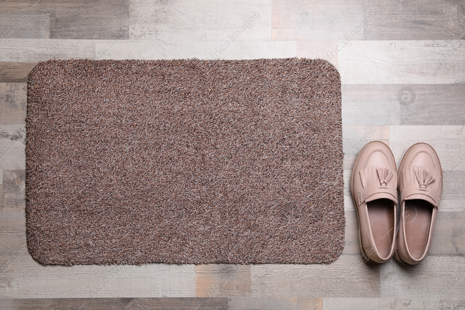 Photo of New clean door mat and shoes on floor, flat lay
