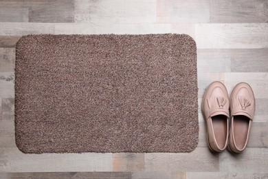 New clean door mat and shoes on floor, flat lay