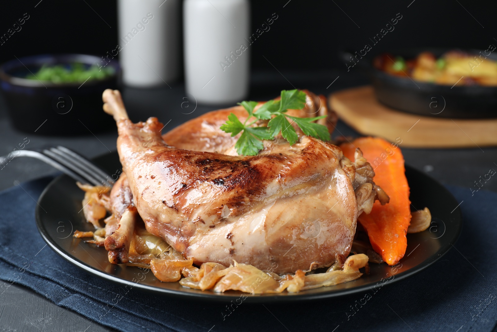 Photo of Tasty cooked rabbit meat with vegetables served on table, closeup