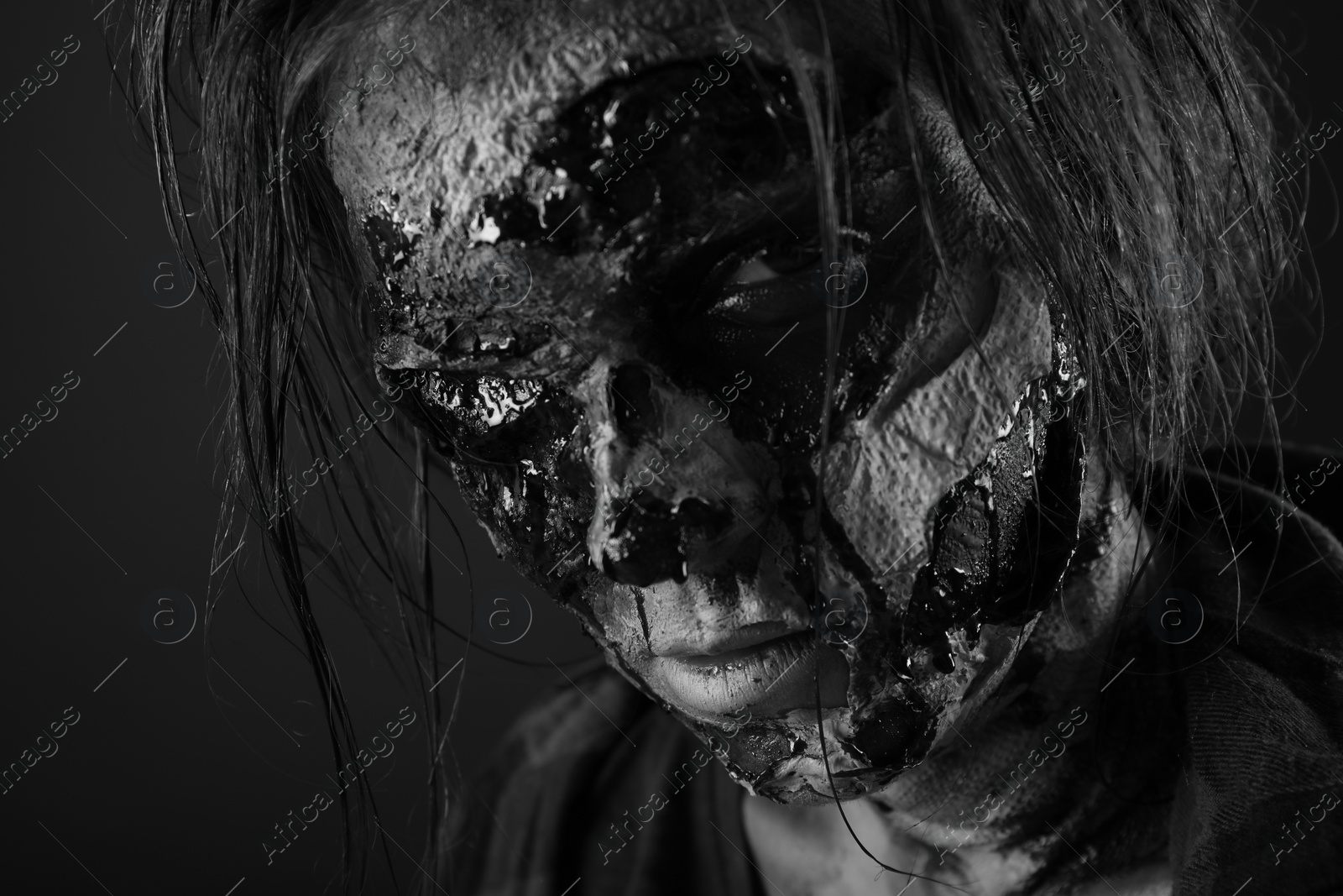 Photo of Scary zombie on dark background, black and white effect. Halloween monster