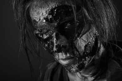 Photo of Scary zombie on dark background, black and white effect. Halloween monster