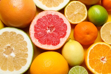 Different ripe citrus fruits as background, top view