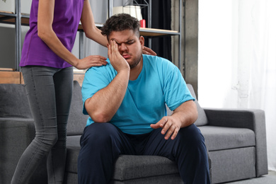 Photo of Woman comforting her depressed overweight friend at home