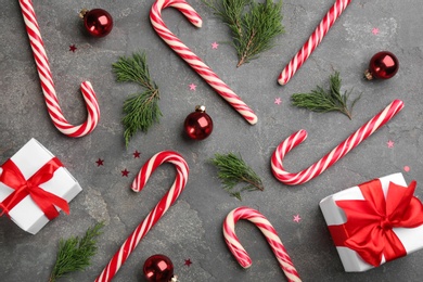 Photo of Flat lay composition with candy canes and Christmas decor on grey table