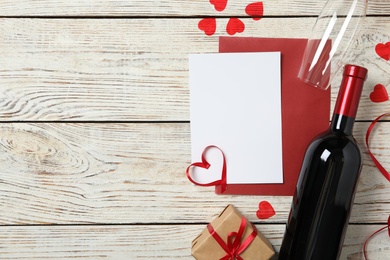 Photo of Flat lay composition with blank card on white wooden background, space for text. Valentine's Day celebration