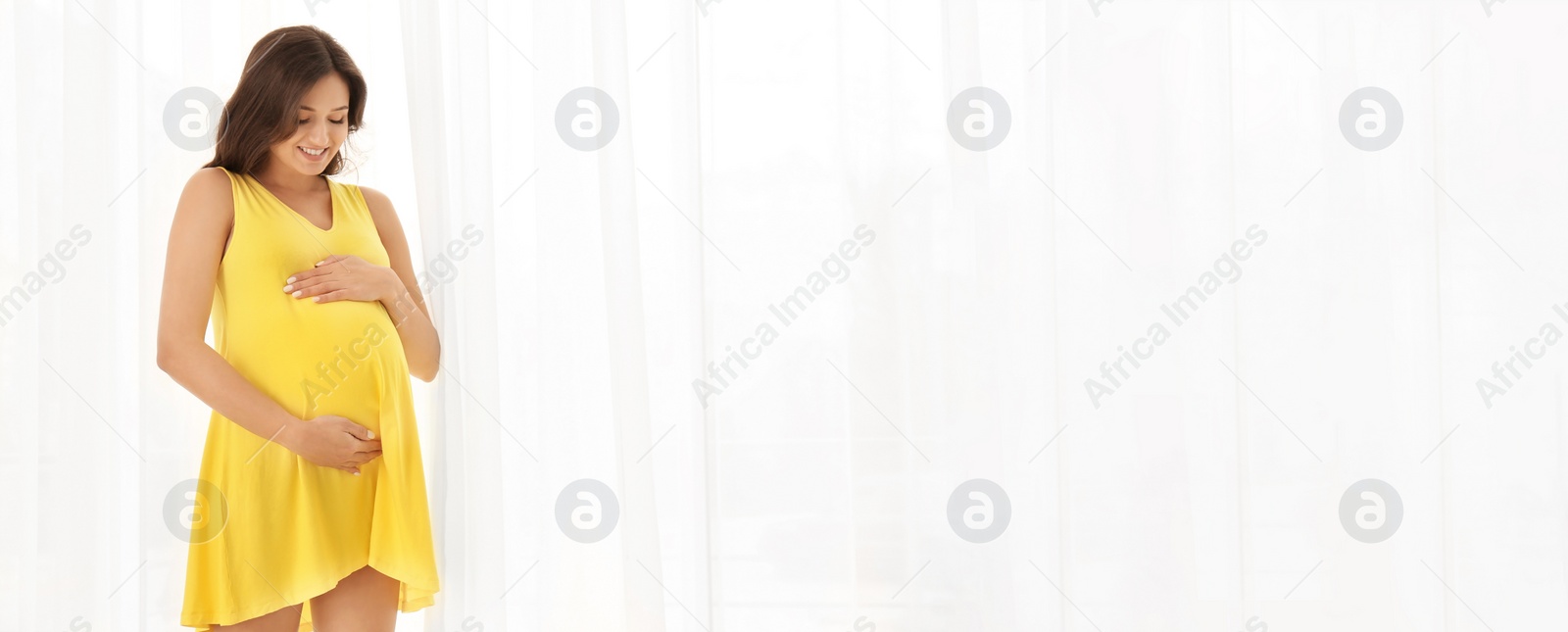Image of Beautiful pregnant woman near window, space for text. Banner design