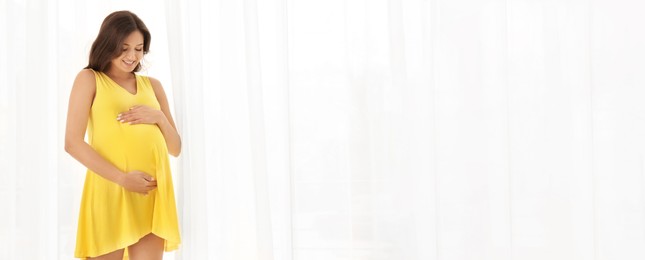 Beautiful pregnant woman near window, space for text. Banner design