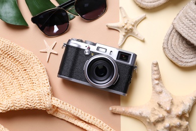 Photo of Flat lay composition with retro camera and sunglasses on color background