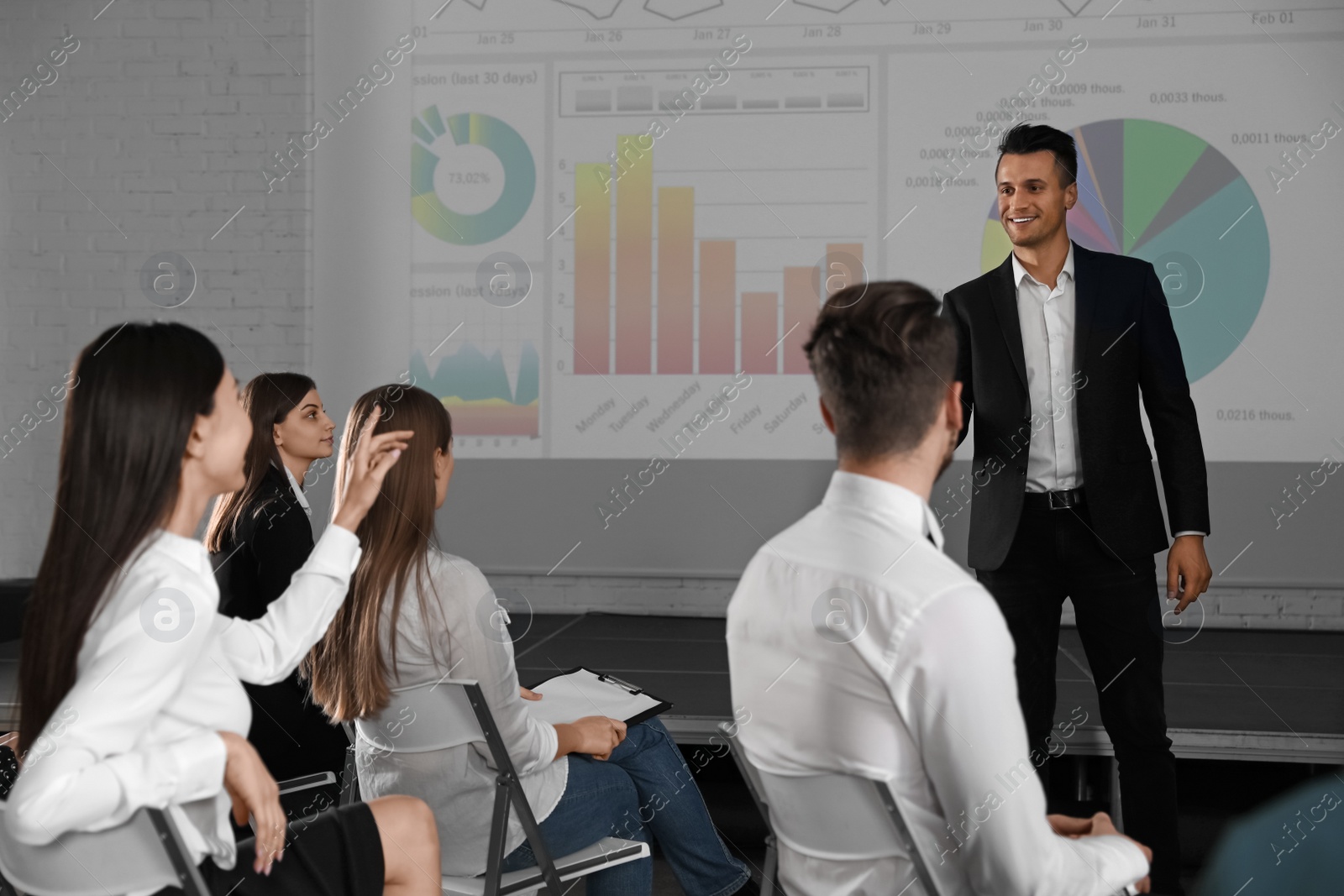 Photo of Male business trainer giving lecture in conference room with projection screen