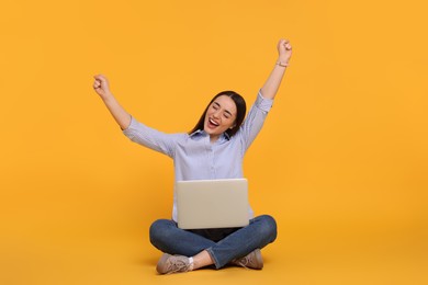 Photo of Happy young woman with laptop on yellow background