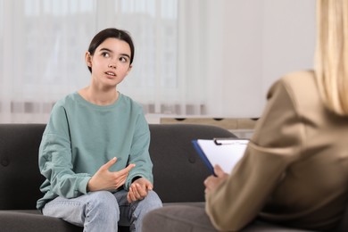 Psychologist working with teenage girl in office. Teenager problems