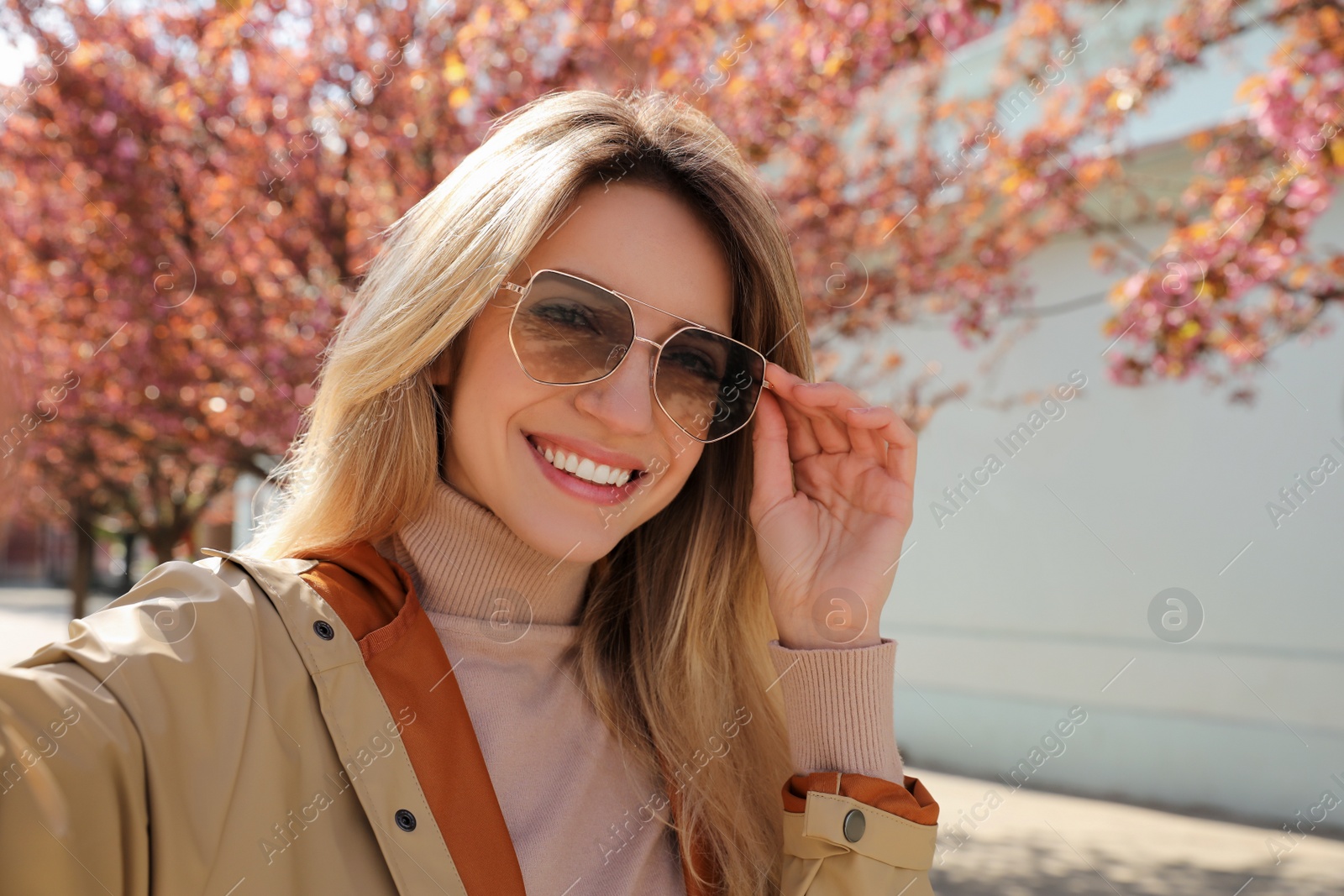 Photo of Young woman taking selfie on city street