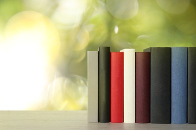 Image of Many hardcover books on table against blurred background, space for text