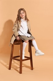 Fashion concept. Stylish girl posing on pale orange background