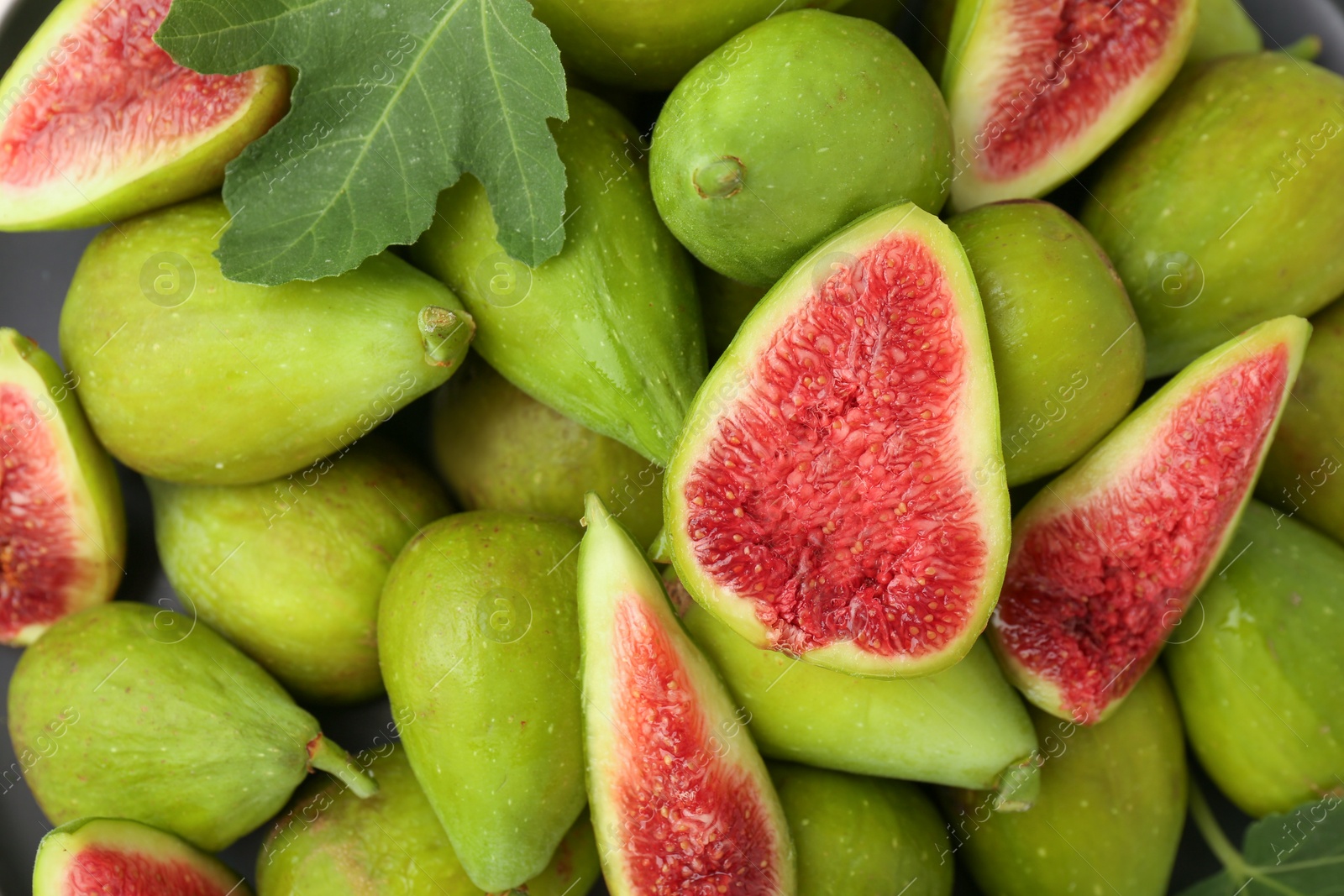 Photo of Cut and whole green figs as background, top view.