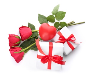 Beautiful gift boxes, roses and toy heart on white background, top view. Valentine's day celebration