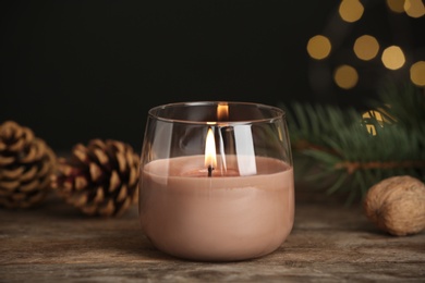 Photo of Burning candle in glass holder on wooden table