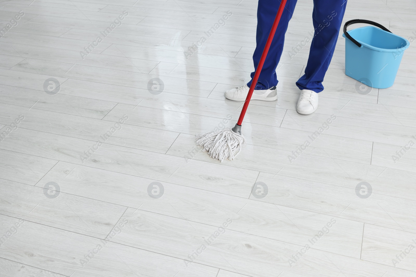 Photo of Man cleaning floor with mop indoors, closeup. Space for text