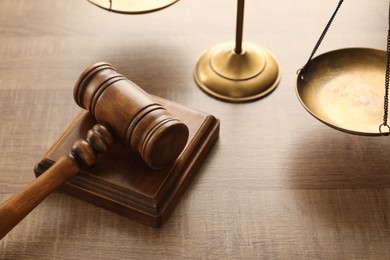 Photo of Law concept. Gavel and scales of justice on wooden table, closeup