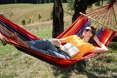 Young woman resting in hammock outdoors on sunny day