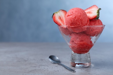 Photo of Delicious strawberry ice cream served on grey table. Space for text